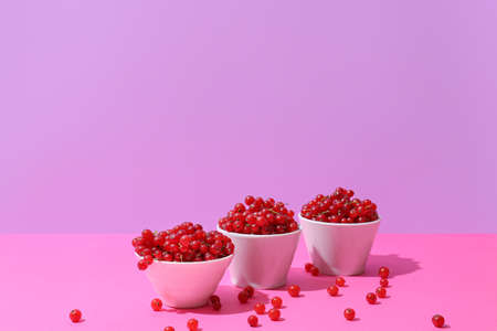 Bowls with fresh red currants on color backgroundの写真素材