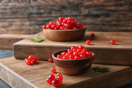 Bowls with fresh red currants on table, closeup