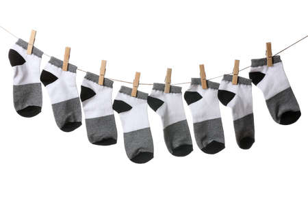 Many socks hanging on rope against white background