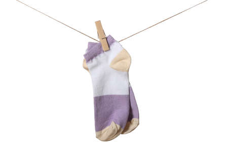 Pair of socks hanging on clothesline against white backgroundの写真素材