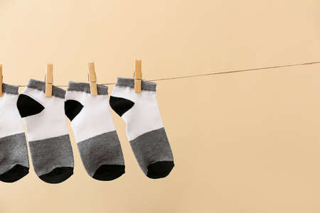 Many socks hanging on rope against color background, closeupの写真素材