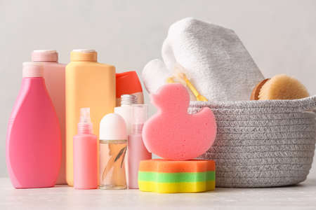 Set of different cosmetic products and bath accessories on light background, closeup