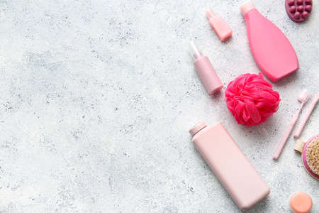 Set of cosmetics and bath accessories on light background
