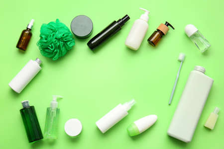 Frame made of cosmetic products, toothbrush and bath sponge on green backgroundの写真素材