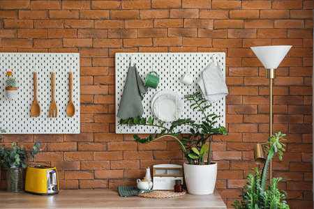 Peg boards with kitchenware hanging on brick wallの写真素材