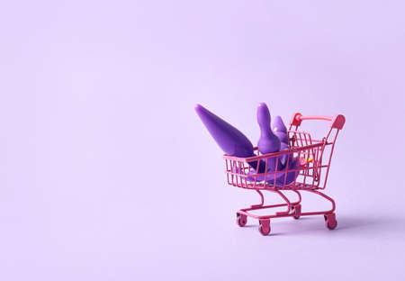 Shopping cart with different sex toys on color backgroundの写真素材