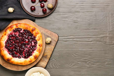 Plate with tasty cherry khachapuri, cottage cheese and quail eggs on wooden backgroundの写真素材