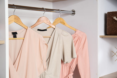 Hangers with stylish clothes female in wardrobe