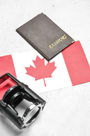 Canadian flag with passport and stamp on white backgroundの写真素材