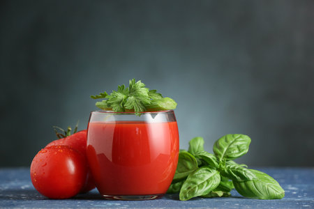 Glass of tasty tomato juice on dark backgroundの写真素材