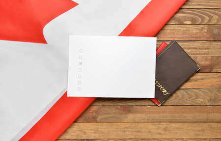 Voting sheet with passports and Canadian flag on wooden backgroundの写真素材