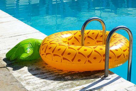 Inflatable ring on ladder in swimming pool