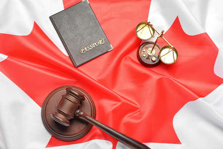Scales of justice, passport and judge's gavel on Canadian flagの写真素材