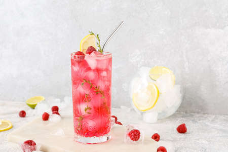 Glass of tasty raspberry lemonade on light backgroundの写真素材