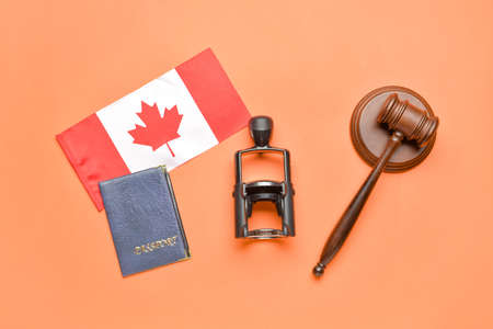 Canadian flag with stamp, passport and judge's gavel on red backgroundの写真素材