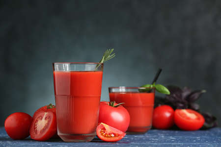 Glass of tasty tomato juice on dark backgroundの写真素材