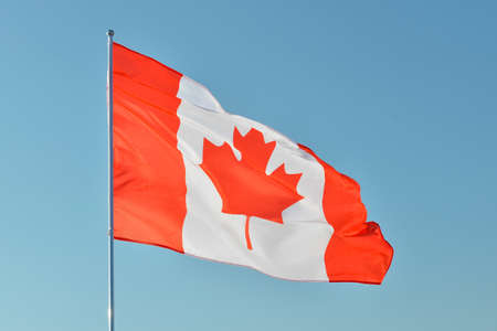 Waving flag of Canada against blue skyの写真素材