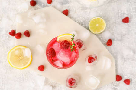 Composition with glass of tasty raspberry lemonade on light backgroundの写真素材