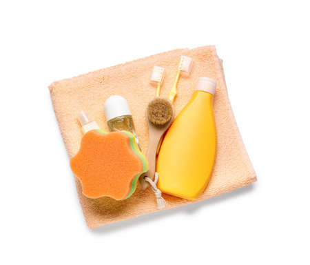 Towel, bottles of cosmetic products, toothbrushes, massage brush and bath sponge on white background