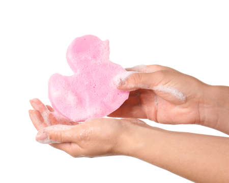 Female hands with soapy duck shaped bath sponge on white background