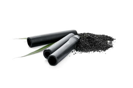 Activated carbon powder and black bamboo sticks on white backgroundの写真素材