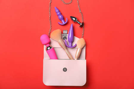 Sex toys, bag and cosmetics on color backgroundの写真素材
