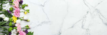 Beautiful flowers on light marble background with space for text