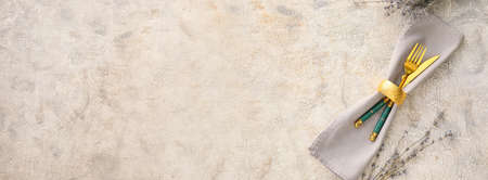 Napkin and cutlery for table setting on light grunge background with space for textの写真素材