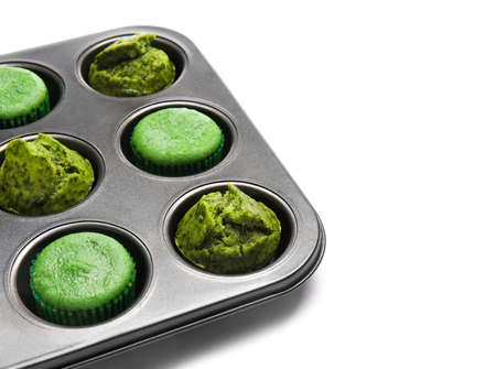 Baking tin with tasty spinach muffins on white background, closeupの写真素材