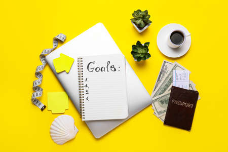 Notebook with empty to do list, laptop, passport and money on color background. new year goalsの写真素材