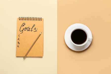 Notebook with empty to do list and cup of coffee on color background. new year goals