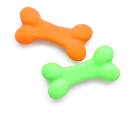 Green and orange erasers in shape of bones on white background