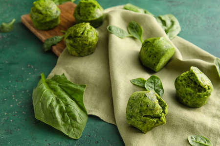 Tasty spinach muffins on color backgroundの写真素材