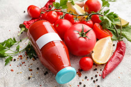Bottle of tasty tomato juice on light backgroundの写真素材