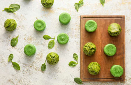 Composition with tasty spinach muffins on light background