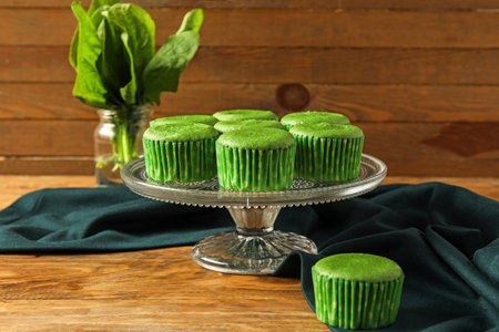 Stand with tasty spinach muffins on wooden backgroundの写真素材