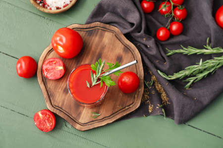 Glass of tasty tomato juice on wooden backgroundの写真素材