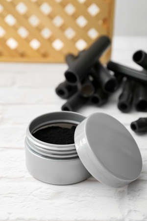 Jar with activated charcoal tooth powder on tableの写真素材