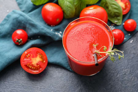 Glass of tasty tomato juice on dark backgroundの写真素材