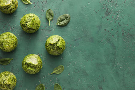 Tasty spinach muffins on color backgroundの写真素材