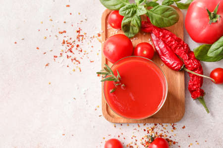 Glass of tasty tomato juice on light backgroundの写真素材