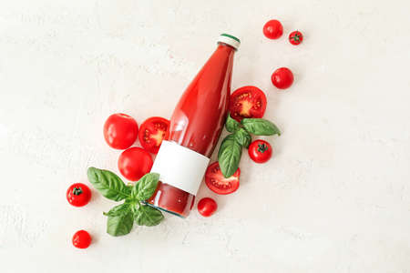 Bottle of tasty tomato juice on light backgroundの写真素材