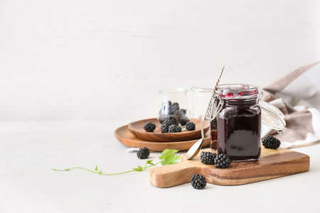 Jar of tasty blackberry jam on light backgroundの写真素材