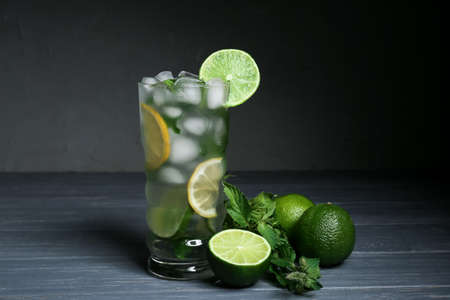 Glass of fresh mojito and limes on table