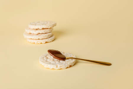 Crunchy rice crackers with melted chocolate on color backgroundの写真素材