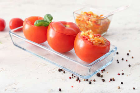 Baking dish with stuffed tomatoes on light backgroundの写真素材