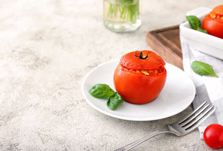 Plate with tasty stuffed tomato on light backgroundの写真素材