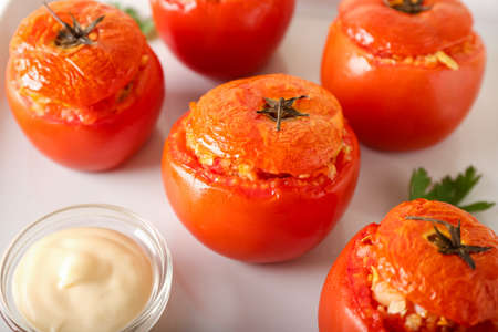 Tasty stuffed tomatoes with sauce on light backgroundの写真素材