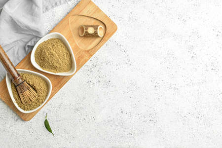 Bowls with powdered matcha tea and chasen on light backgroundの写真素材