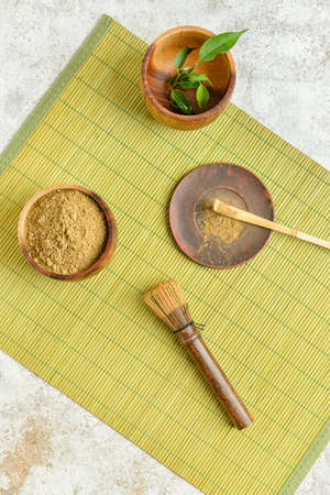 Composition with powdered matcha tea, chasen and chashaku on light backgroundの写真素材
